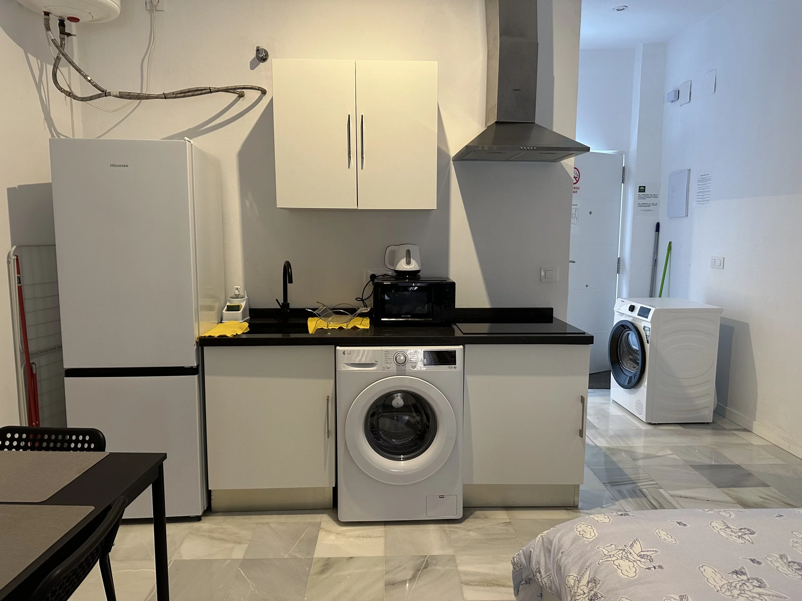 Cocina del Apartamento 1 con frigorífico, encimera y lavadora.