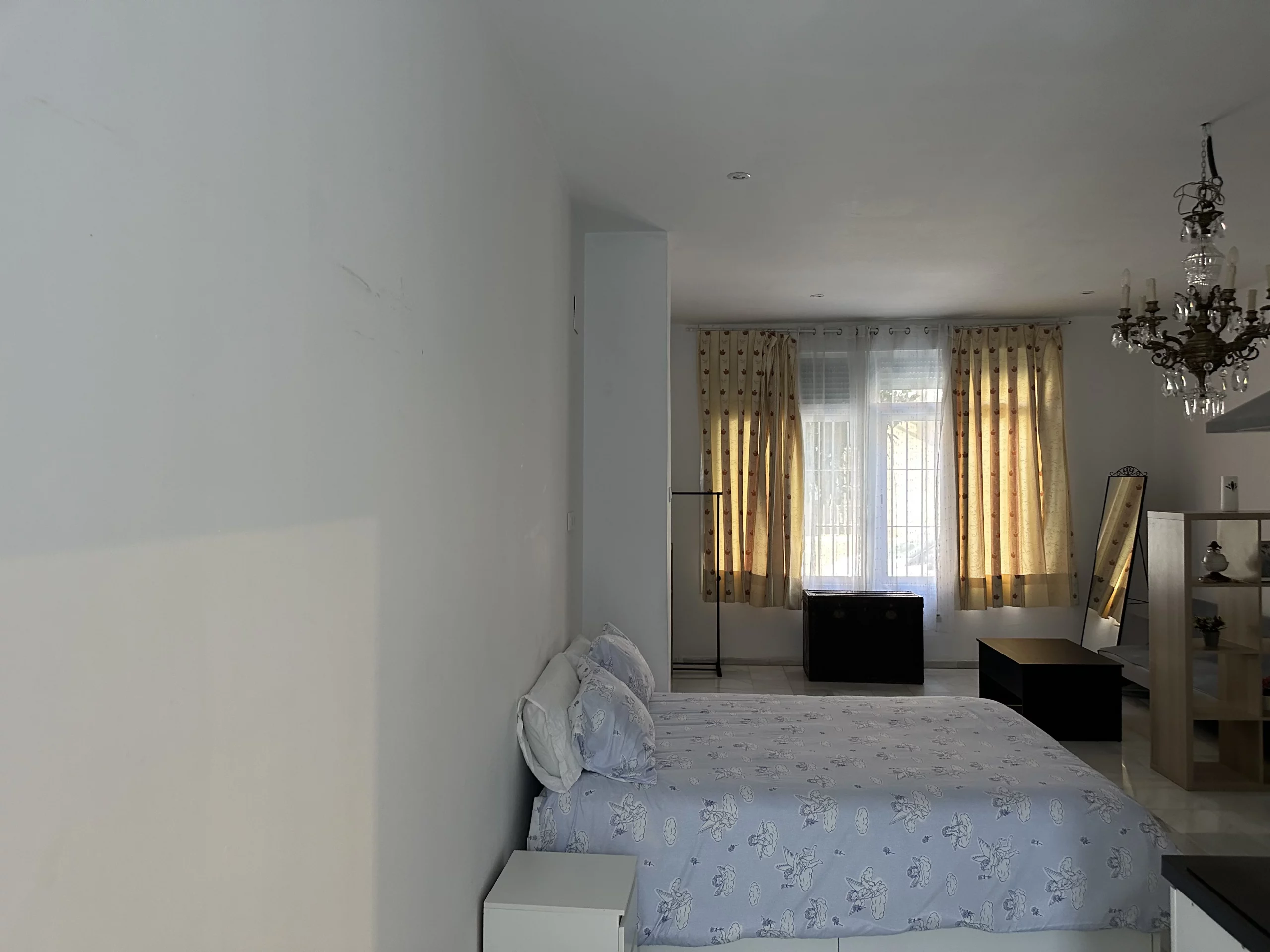 Cama y zona de estar del Apartamento 1 vistas hacia el ventanal.