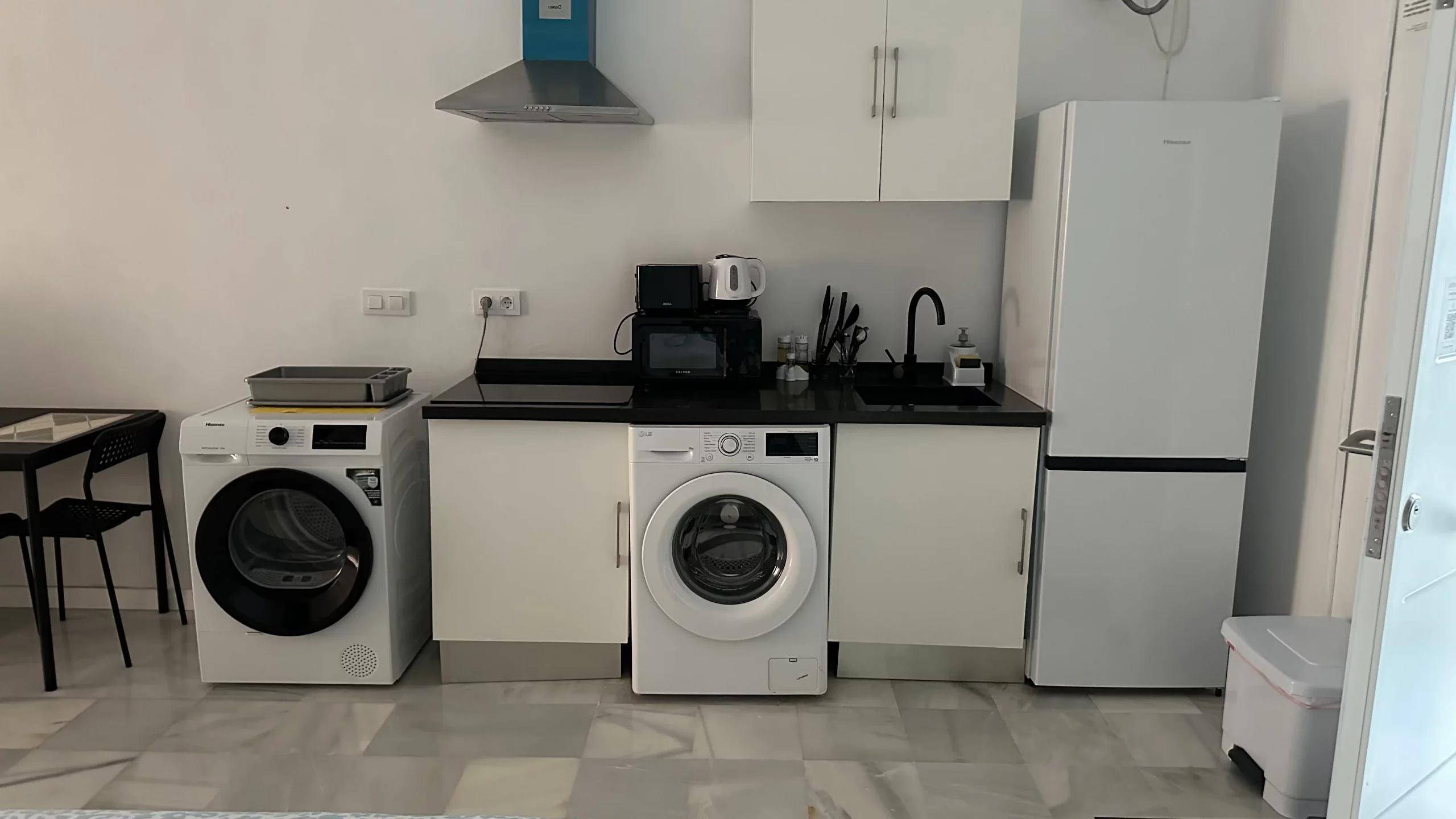 Cocina lineal del Apartamento 3 con armarios, fregadero, electrodomésticos y frigorífico.