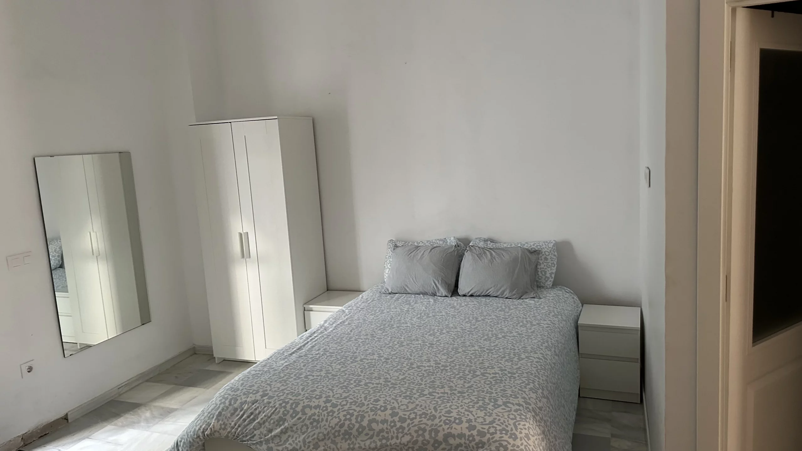 Dormitorio del Apartamento 3 con cama doble, mesillas, armario y espejo.