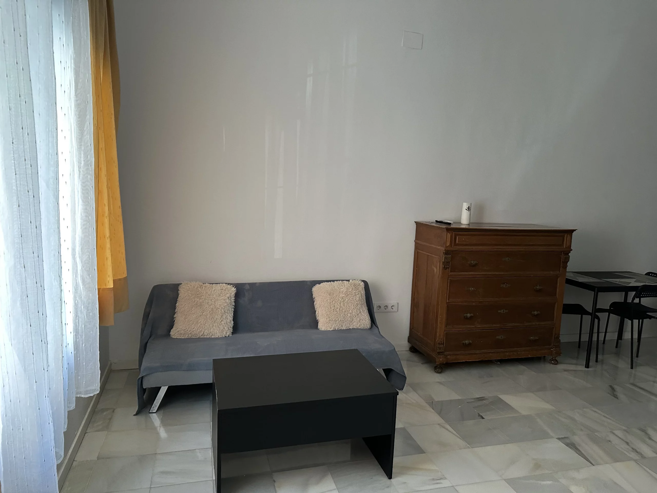 Salón del Apartamento 3 con sofá, mesa baja, cómoda y comedor.